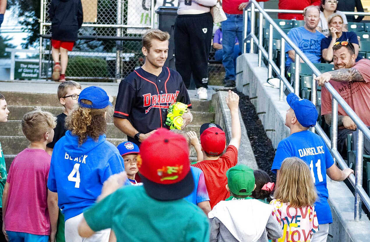 Kids crowding the rail to meet a Dragons player after the game.